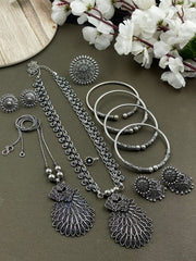 Oxidized jewelry set featuring two pendants of peacock design, a ring, earrings, kada, nosepin, and toe ring, all crafted in brass with intricate detailing.